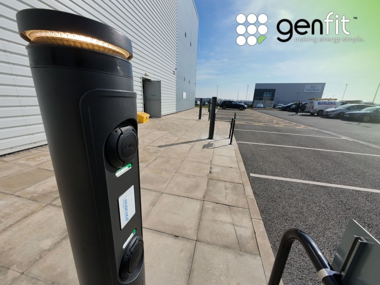 A black ratio io7 charging pillar with a yellow lighting ring around the top, in-situ in a car park.